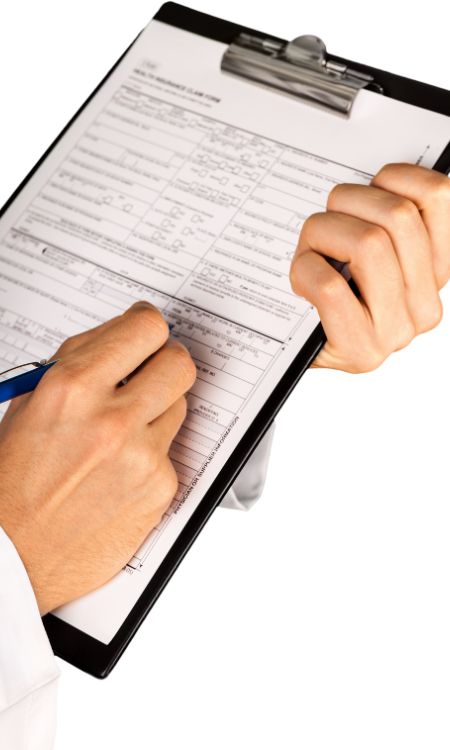 Hand Filling a Health Insurance Document with Stethoscope